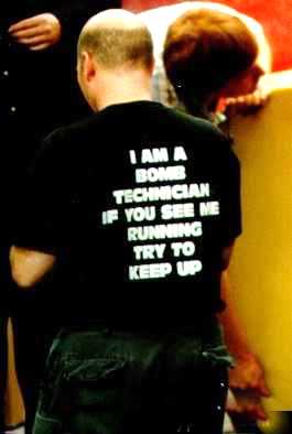 1979 Ford Bronco II - A person wears a black t-shirt with white text that reads 'I AM A BOMB TECHNICIAN IF YOU SEE ME RUNNING TRY TO KEEP UP.'