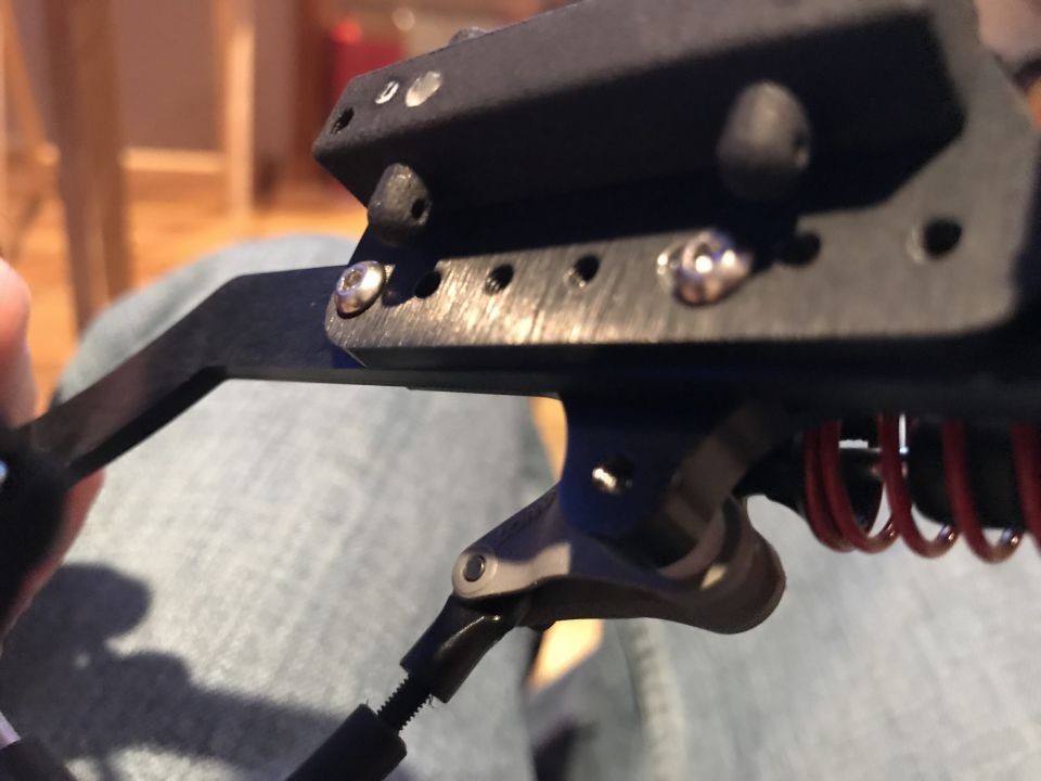 Close-up of black metal mechanism with screws and red springs.