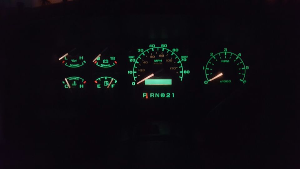 Illuminated dashboard of a 1996 Ford Bronco at night.