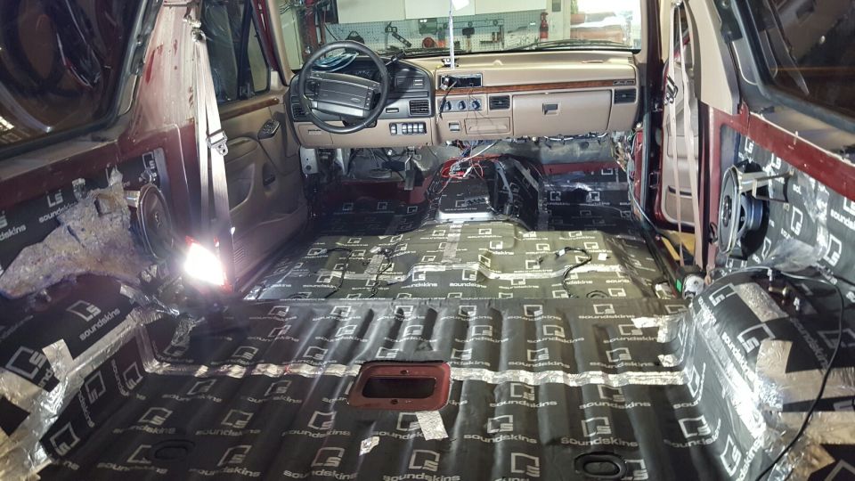 Interior of a classic Ford Bronco with sound deadening material on the floor and doors.