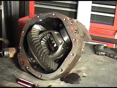 1996 Ford Bronco - A differential housing with gears is shown on a workbench. A red tool chest is visible in the background.