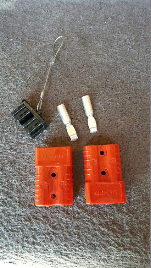 1996 Ford Bronco - Two orange Anderson SB50 connectors and associated terminals are laid out on a textured gray surface.