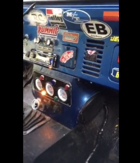 1974 Ford Bronco - Interior view of a blue vehicle, aftermarket gauges and many racing stickers on the dash.