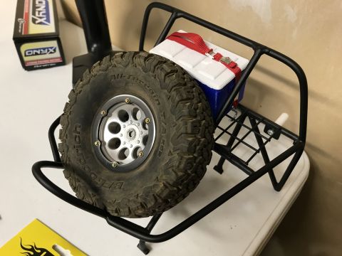 1989 Ford Bronco - A spare tire and cooler rack are shown, with text visible on a nearby battery pack.