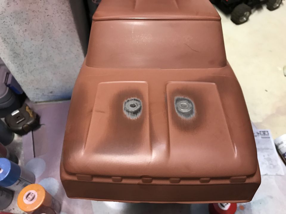 Reddish-brown RC car body, front view, showing hood with two circular headlight indentations.