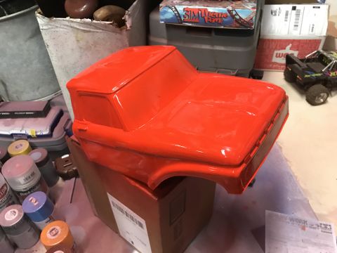 1989 Ford Bronco - A bright orange, unmounted truck body sits on top of a cardboard box. Several cans of spray paint are visible in the foreground.