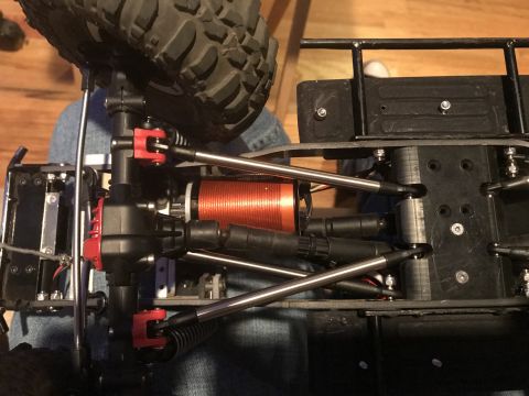 1989 Ford Bronco - Close-up view of the chassis and drivetrain of a remote-controlled vehicle, highlighting the motor and suspension.