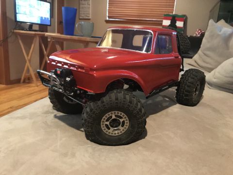 1989 Ford Bronco - This red RC truck features oversized tires and a custom chrome bumper, resembling a classic pickup body style.