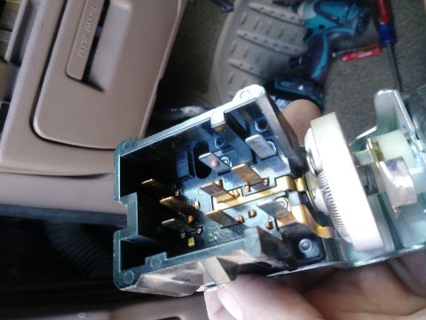1996 Ford Bronco - A close-up view of the electrical connector for a vehicle's headlight switch, showing the metal terminals and plastic housing. In the backg…