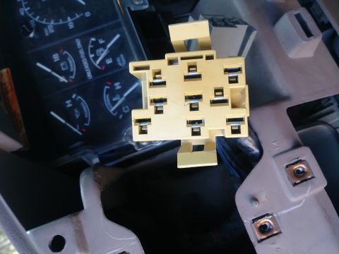 1996 Ford Bronco - A close-up view of a yellow electrical connector with multiple terminals, possibly for a vehicle's dashboard, is shown. In the background,…