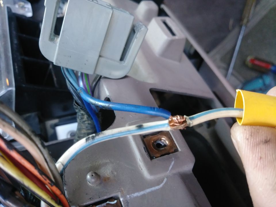 Close-up of spliced wires with yellow loom and electrical connector