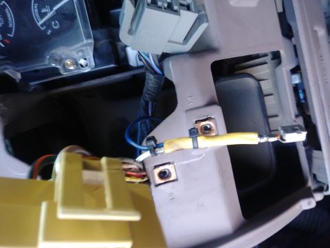 1996 Ford Bronco - Close-up view of wiring harness and connectors behind a vehicle's dashboard, with a portion of the instrument cluster visible.