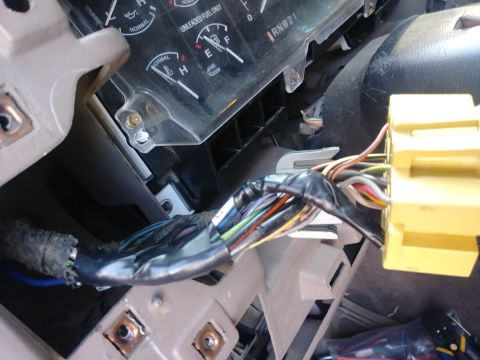 1996 Ford Bronco - A close-up interior shot shows a bundle of wires connected to a yellow electrical connector, likely part of the dashboard or steering colum…