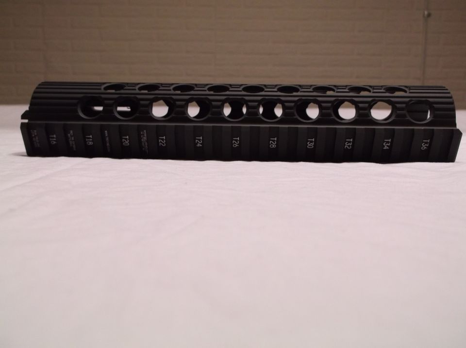 Black rifle handguard with numbered T-slots.