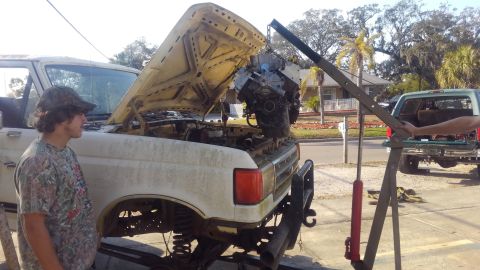 1988 Ford Bronco - dropping the engine in. had to pull the truck from its resting spot onto cement then take the front tires off to get it to go over.. once i…