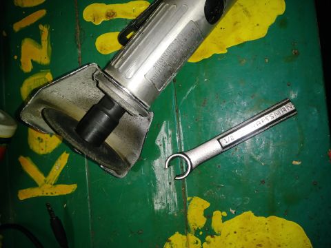 1996 Ford Bronco - A Craftsman 1/2 inch wrench rests on a green surface with yellow paint splatters. A silver angle grinder with a black cutting disc is also…