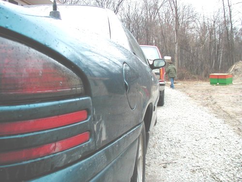 1995 Dodge Intrepid rear quarter panel and taillight, side view. Another vehicle and a person are visible in the background