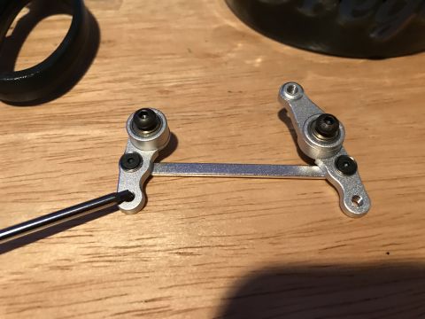 1989 Ford Bronco - A close-up shot shows a silver metal linkage assembly with black screws and bearings, possibly for a remote control car or similar device,…