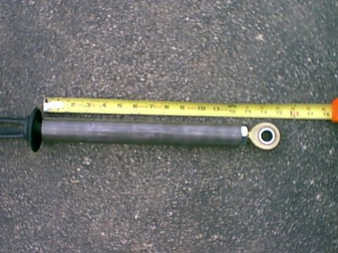 1978 Ford Bronco - Measuring a shock absorber with a tape measure. The part appears to be around 10 inches long.