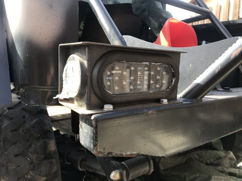 1987 Suzuki Samurai - This vehicle's rear light assembly features an array of LED lights and a circular reflector, mounted on a frame.