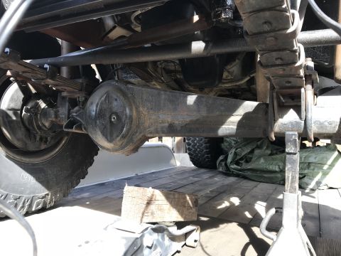 1987 Suzuki Samurai - Close-up of a vehicle's rear axle and suspension components, resting on jack stands.