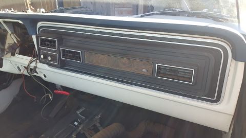 1973 Ford F-100 - The interior dashboard of a 1973 Ford F-100 shows woodgrain trim and the Ford logo, indicating its model year.