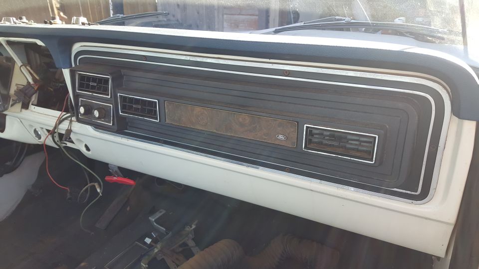 1973 Ford F-100 interior dashboard with woodgrain trim and Ford logo