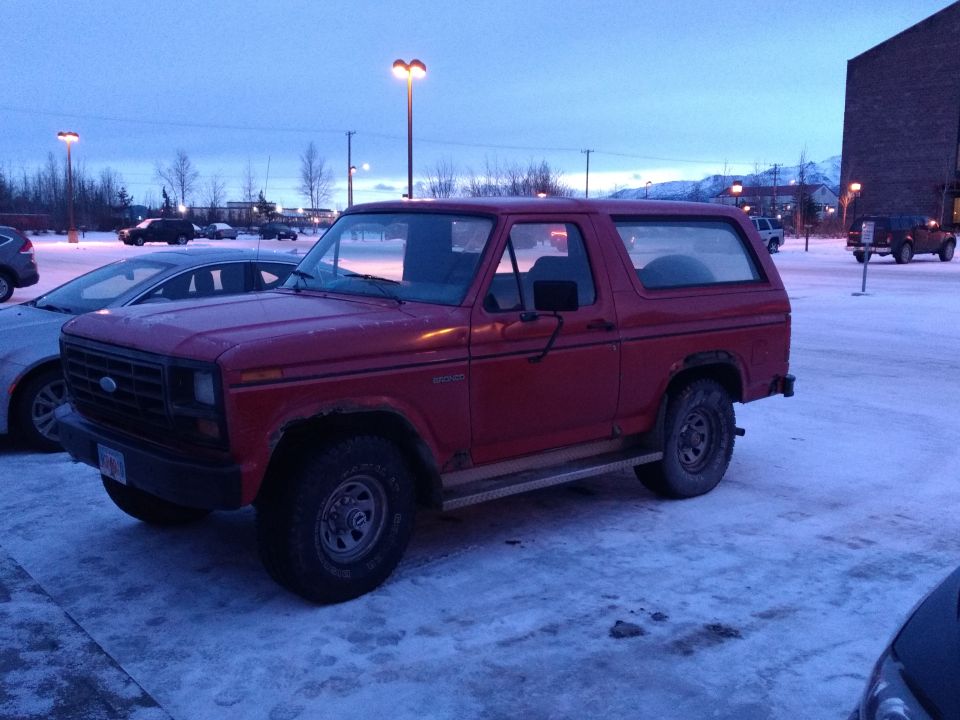 Red 1982 Ford Bronco parked in a snowy lot