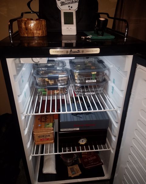 2018 Ford Bronco - A refrigerator is filled with various cigar boxes and containers on its shelves.
