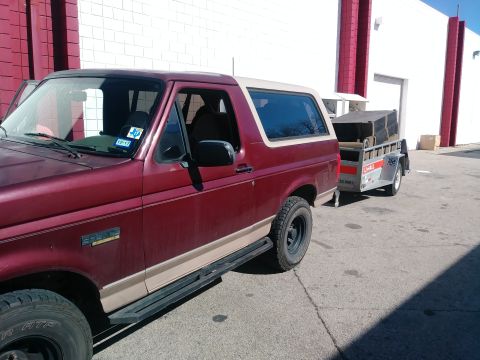 1996 Ford Bronco - A maroon Ford Bronco with tan trim tows a U-Haul trailer.