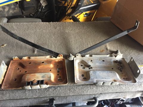 1996 Ford Bronco - Comparison of two battery trays and their hold-down brackets.