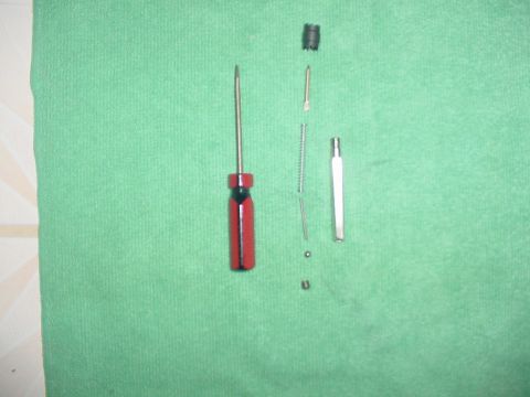 1967 Mercury Cougar - Carburetor components and a screwdriver are laid out on a green textured surface.
