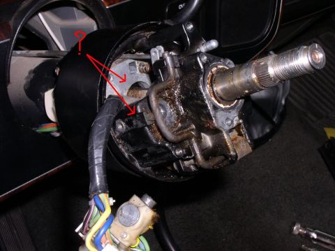 1990 Ford Bronco - The internal components of a vehicle's steering column are shown, with wiring harnesses and mechanical parts exposed.