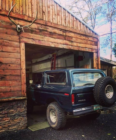 1979 Ford Bronco - 1978 Ford Bronco partially inside a rustic wooden garage, with an elk skull mounted on the wall.