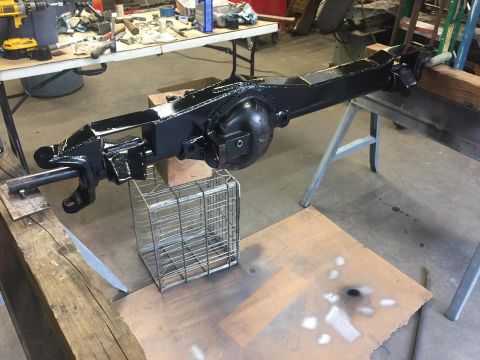 1979 Ford Bronco - Vehicle axle assembly painted black and undergoing restoration in a workshop setting.