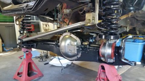 1979 Ford Bronco - Close-up of a vehicle's rear axle and suspension system undergoing maintenance or modification.
