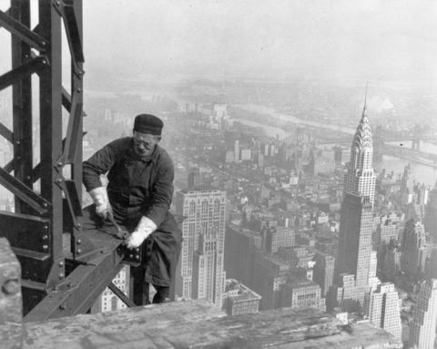 1967 Ford Custom Wagon - A worker secures steel beams high above the city, with the iconic Chrysler Building visible in the distance.