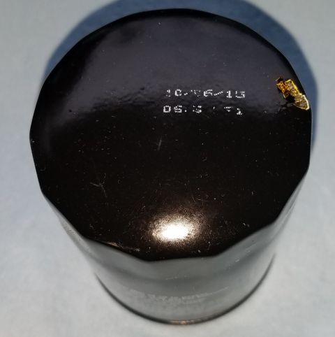 2000 Ford Crown Victoria - A black oil filter is shown with a date and time stamped on its surface.