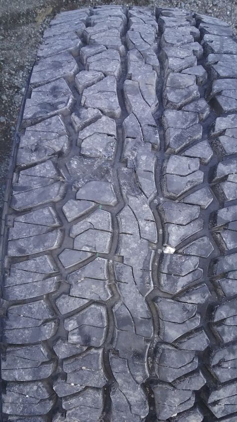 1993 Ford Bronco - A close-up view of a tire's tread pattern, with a small stone embedded in the rubber.