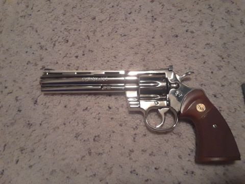 1994 Ford Bronco - A Colt Python revolver with a chrome finish and wooden grips is displayed on a carpeted surface.
