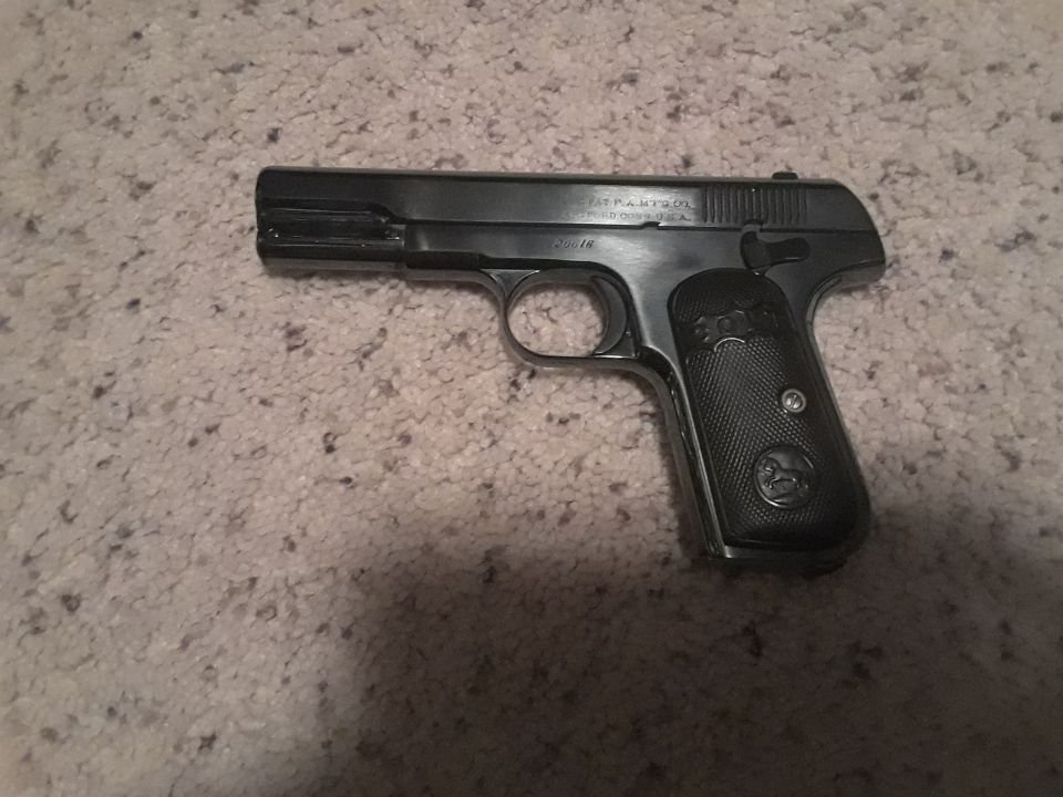 Colt 1903 Pocket Hammerless pistol on carpet