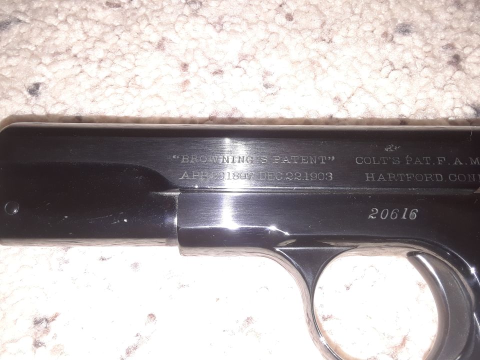 Close-up of a Colt pistol slide with "Browning's Patent" and patent dates visible