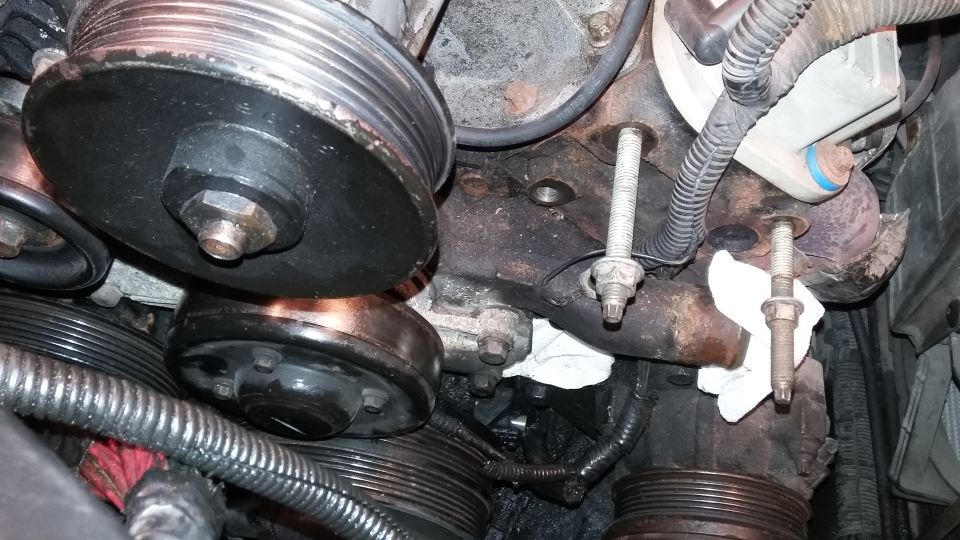 Engine pulleys and mounting bolts with white rags. Watermark reads SUPERMOTORS.NET