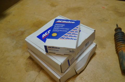 1998 Ford Ranger - ACDelco brake pads and a shock absorber are shown on a concrete surface.