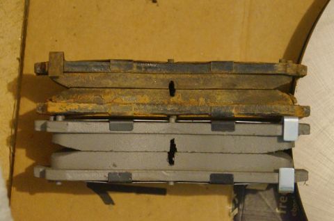 1998 Ford Ranger - Comparison of old, worn brake pads with new ones, showing significant rust on the older set.