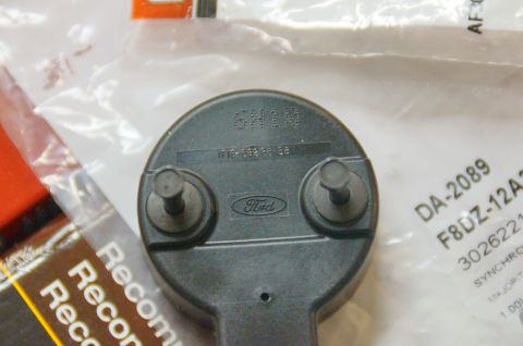 1998 Ford Ranger - This is a close-up of a Ford emblem part, showing its rear with mounting bolts and identifying numbers.