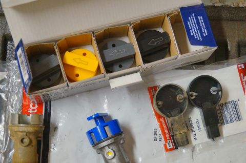 1998 Ford Ranger - Several engine components are laid out, including a box of caps and two sensors, one of which is a Ford Motorcraft part.