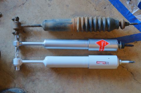 1998 Ford Ranger - Comparison of three shock absorbers, showing one old unit alongside two new replacements.