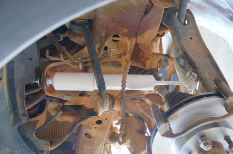 1998 Ford Ranger - Suspension system detail showing a new shock absorber on a rusty truck frame.