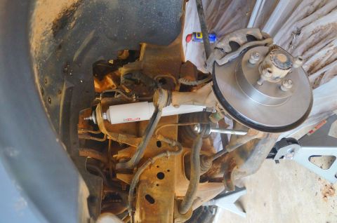 1998 Ford Ranger - Close-up view of a vehicle's front suspension and brake system, showing components like the shock absorber and rotor.
